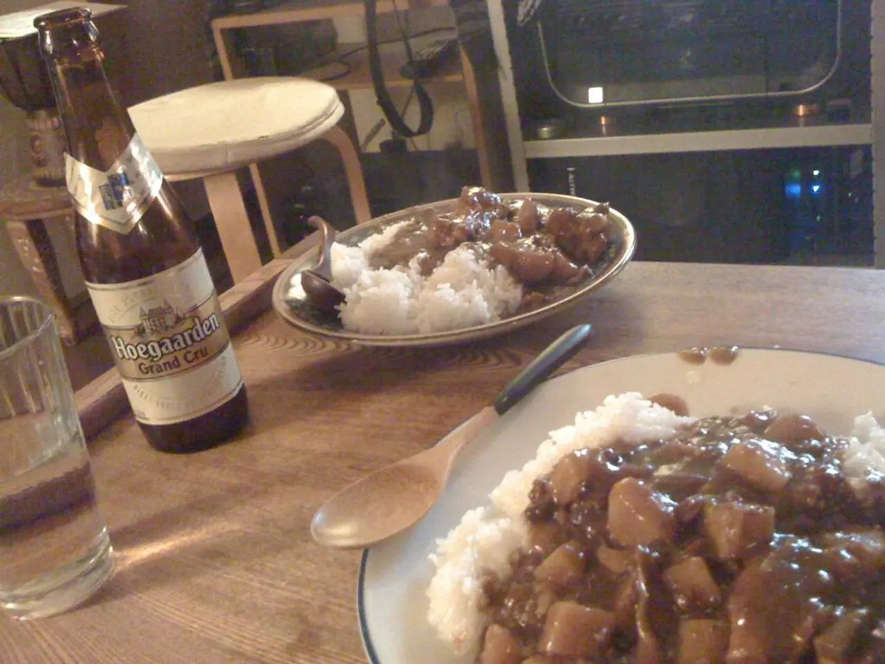 Bottom of the image there is a table, on the table there are some plates, spoons, bottles, glass...