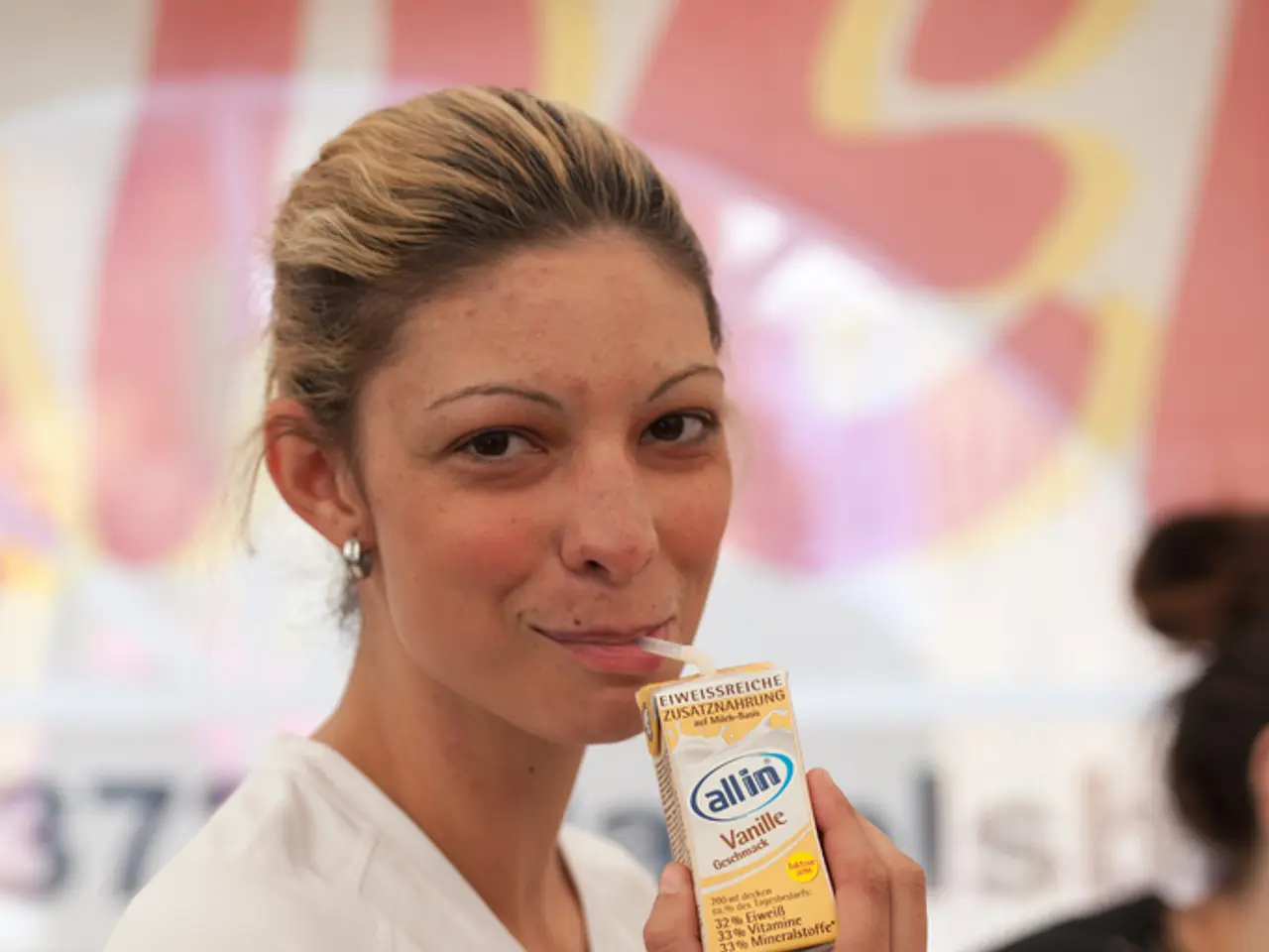 In this image there are two women's in which a woman wearing white T-shirt is drinking a milkshake.