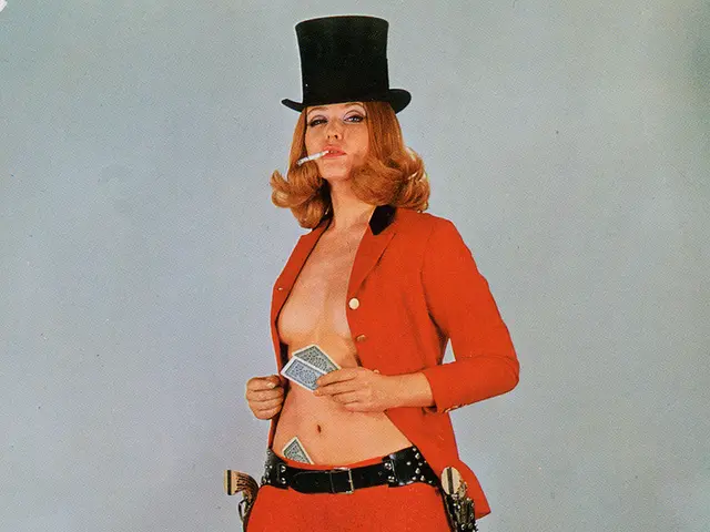 In the image a woman is standing and holding some cards, smoking and she wear a hat. Behind her we...