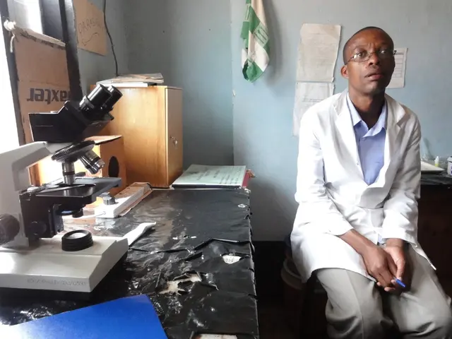 It looks like a science lab, there is a microscope on the table and also a switch board and some...