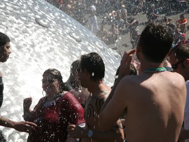 This picture shows few people standing and few are seated on the ground and we see snow drizzling...