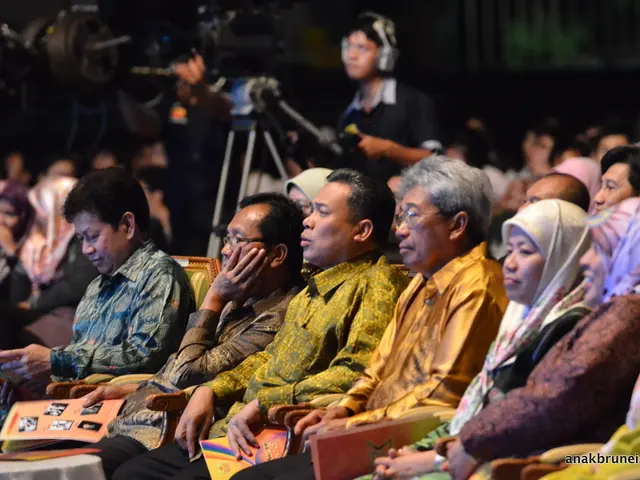 In this picture we can see group of Chinese men and women sitting on the auditorium chair and...