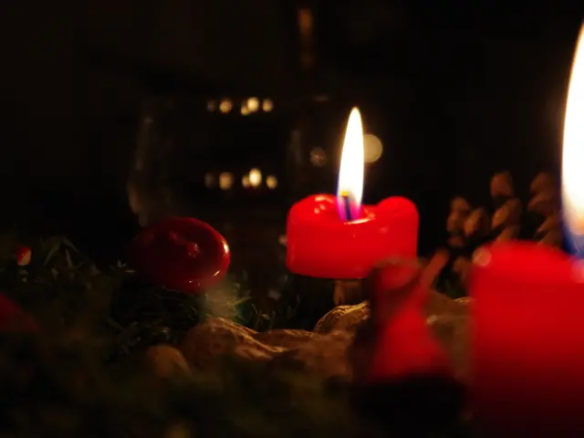 In this image we can see red color candles are burning.